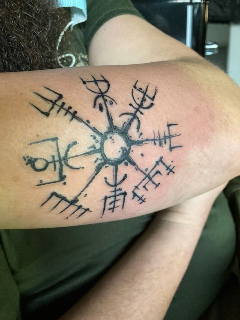 Zwart-wit Vegvisir (Viking kompas) tattoo op de bovenarm.