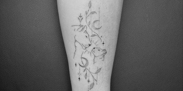 Fineline tattoo van een leeuwin en welp met maan en bladeren.
