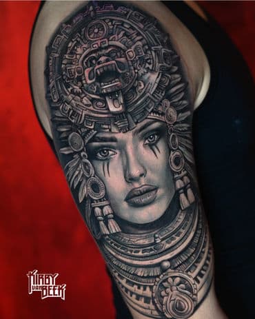 Realistisch portret van vrouw met Azteekse hoofdtooi op bovenarm.