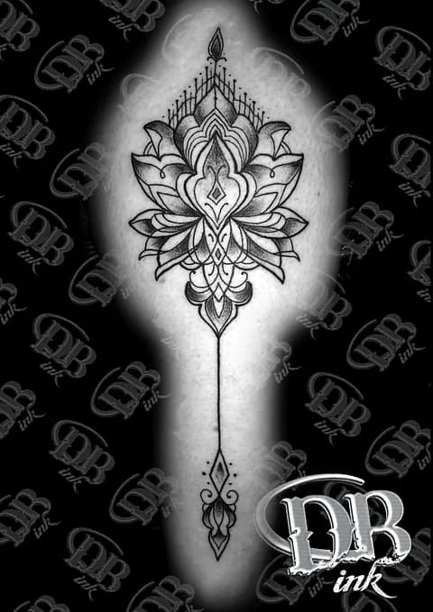 Zwartwerk ornamentale lotus tattoo met geometrische hanger.