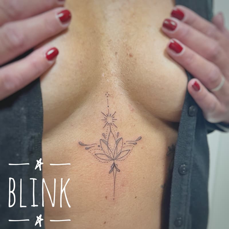 Fineline lotus met unalome en ster op borstbeen.