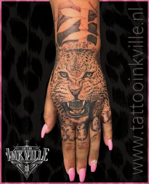 Realistische luipaardkop tattoo op de hand.