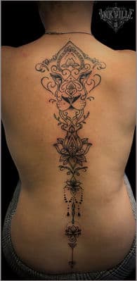 Grote rugtattoo van een gestileerde leeuw, lotus en ornamenten in dotwork.