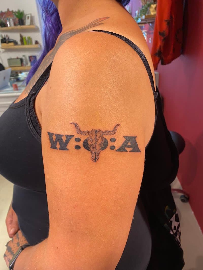 Zwart-wit W:O:A logo met stierenschedel op bovenarm.