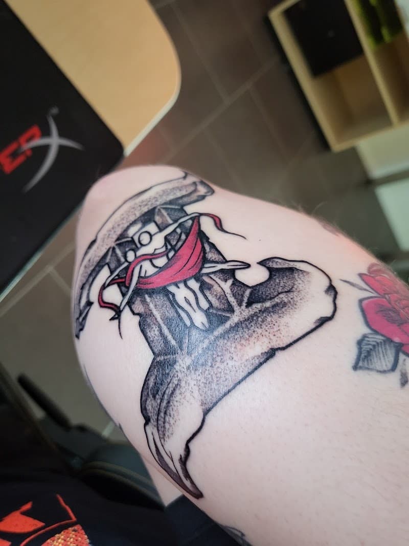 Illustratieve hamer tattoo met rode doek en dotwork shading op de bovenarm.