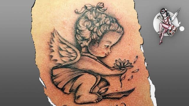 Zwart-wit tattoo van een cherubijntje met een bloem.