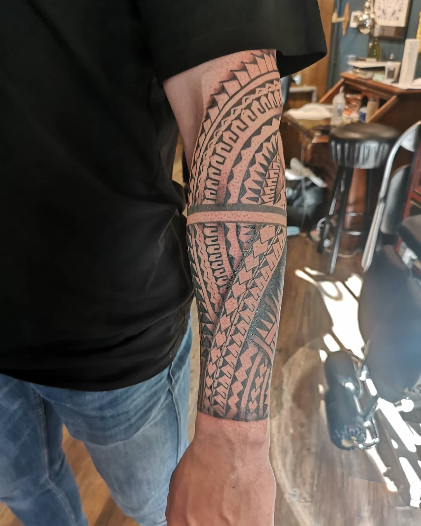 Grote Polynesische tribal tattoo op de onderarm.