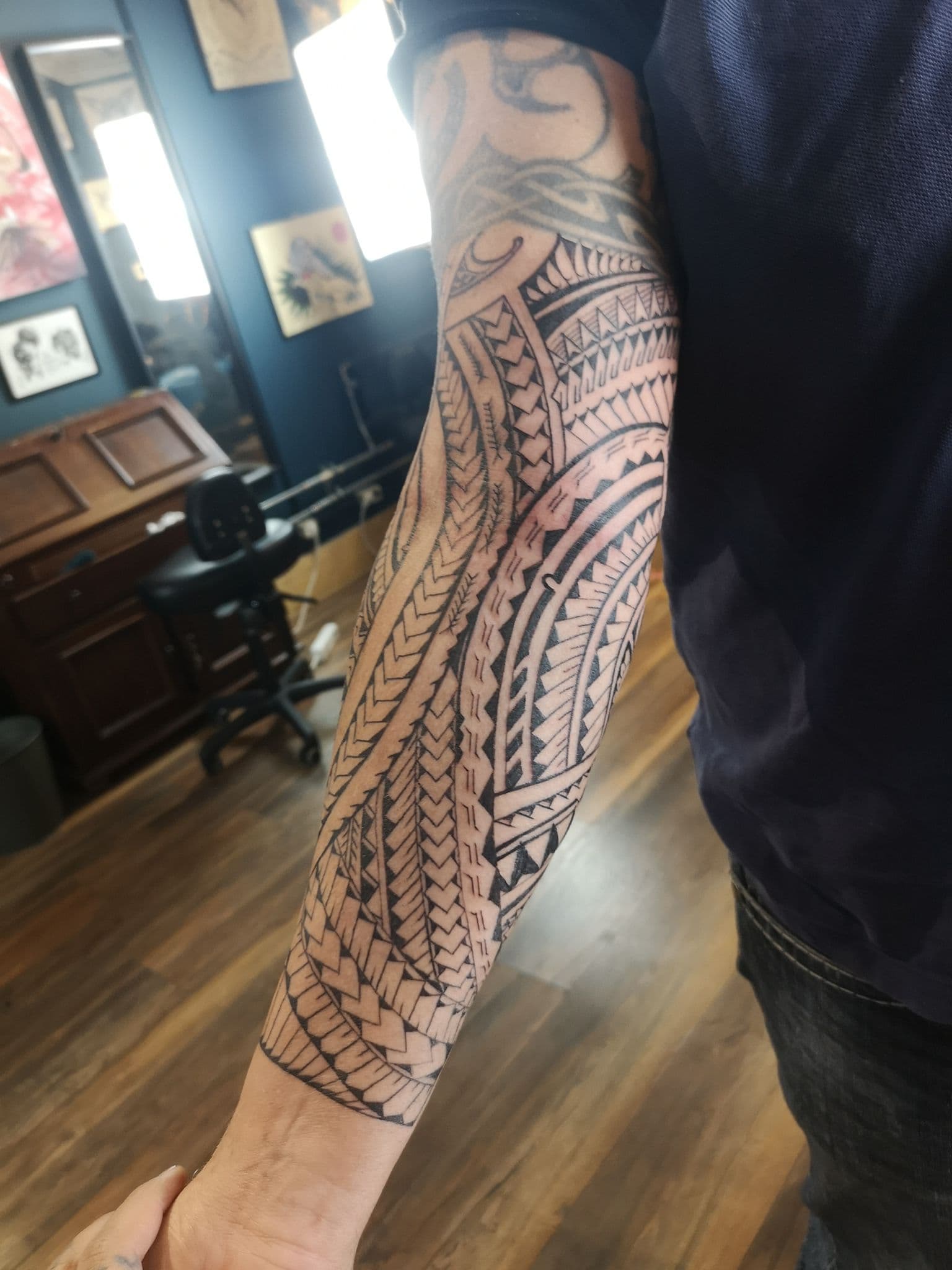 Grote Polynesische tribal tattoo op de volledige onderarm.