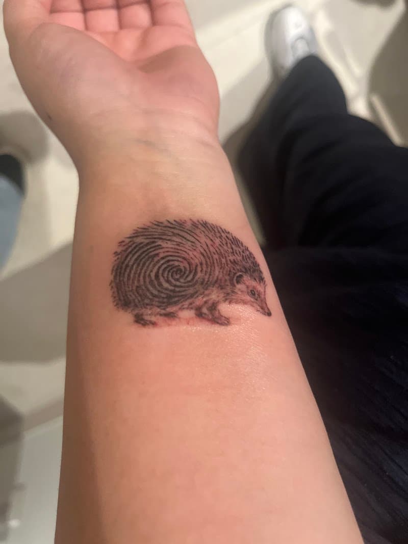 Egel tattoo met vingerafdruk patroon op de pols.