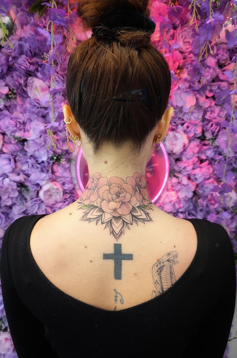 Bloemen mandala nek tattoo, kruis en slang op bovenrug.