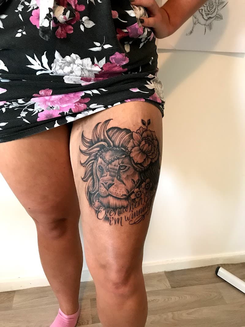 Illustratieve leeuw met bloemen en tekst op bovenbeen.