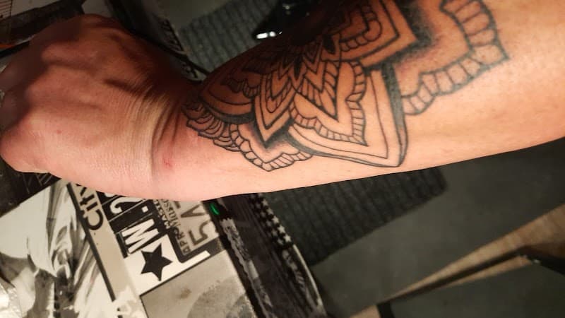 Grote mandala tattoo in blackwork stijl op de onderarm en pols.