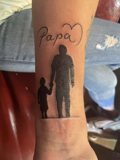 Silhouet van vader en kind hand in hand met 'Papa' en een hartje.