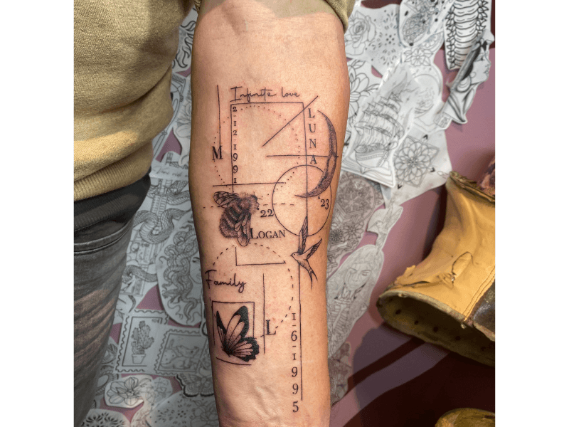Geometrische tattoo met bij, vogel, vlinder, namen en datums op onderarm.