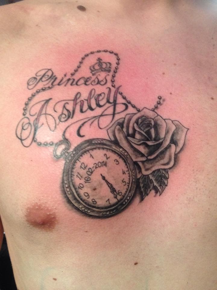 Black & grey tattoo op borst met 'Princess Ashley', zakhorloge, roos en kroon.
