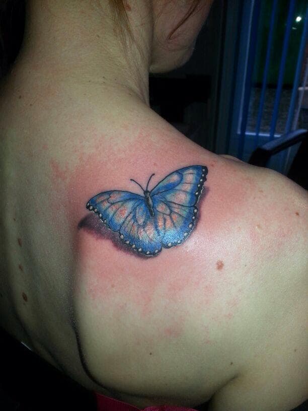 Realistische blauwe vlinder met 3D schaduw op schouderblad.