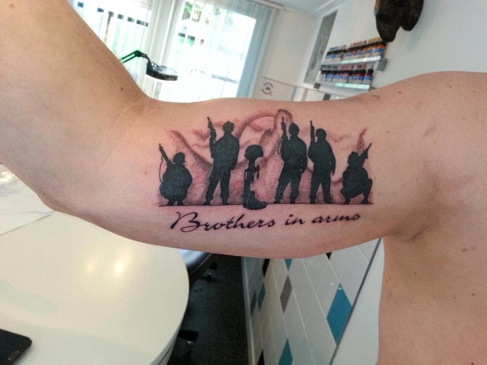 Silhouet van soldaten met 'Brothers in arms' tekst op de binnenkant van de bovenarm.