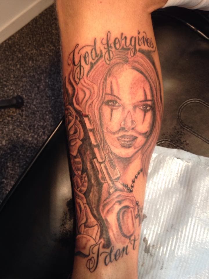 Chicano tattoo van vrouw met pistool en tekst "God forgives I don't".