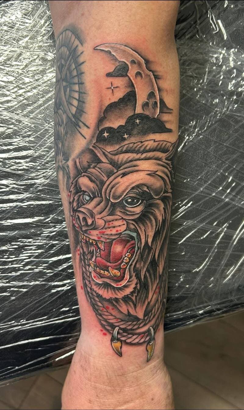 Neo-traditionele wolf met maan en wolken op onderarm.