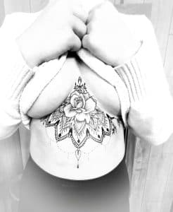 Zwart-wit underbust tattoo met roos en mandala.