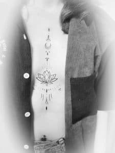 Fineline lotus en maan ornament op de ribben en borstbeen.