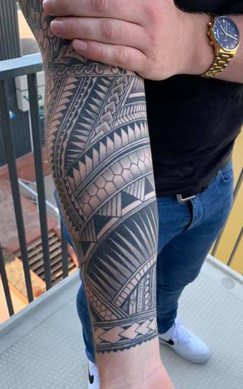 Grote Polynesische tribal tattoo op de onderarm.