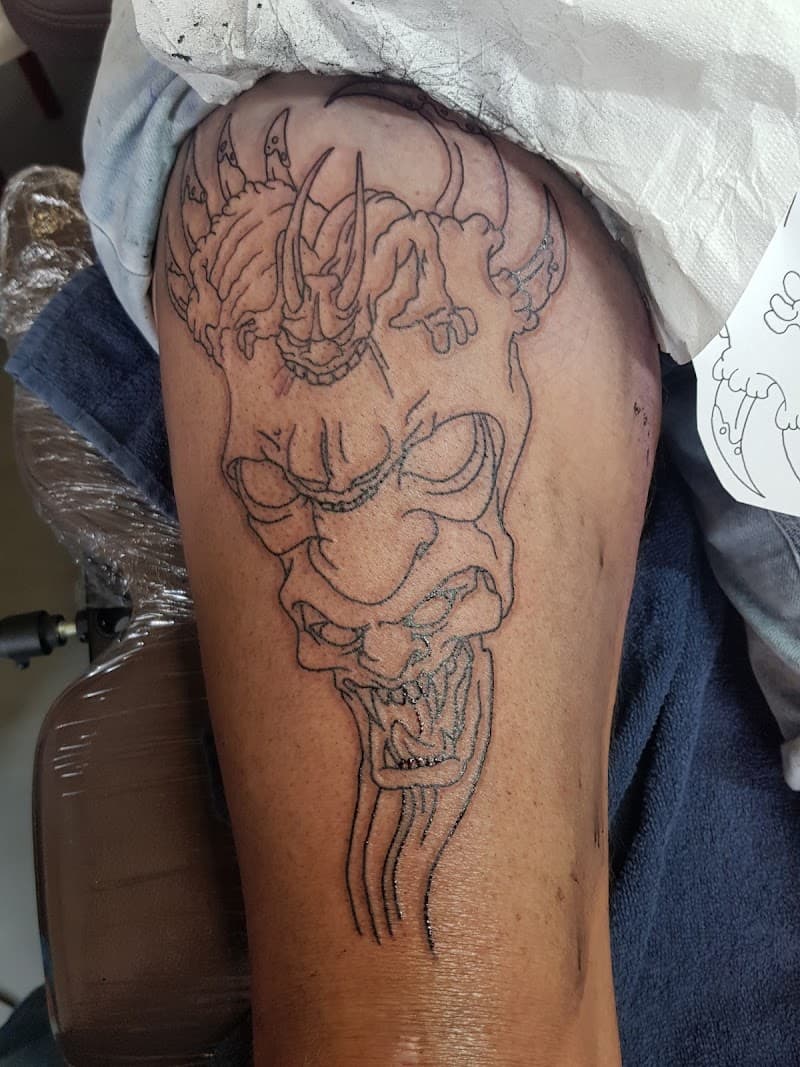 Outline van een Japans Hannya masker en een demon op het bovenbeen.