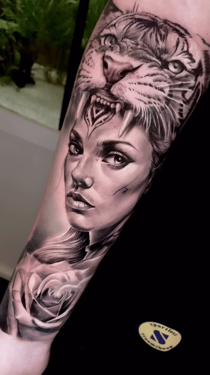 Realistische tattoo van vrouw met tijgerhoofddeksel en roos.