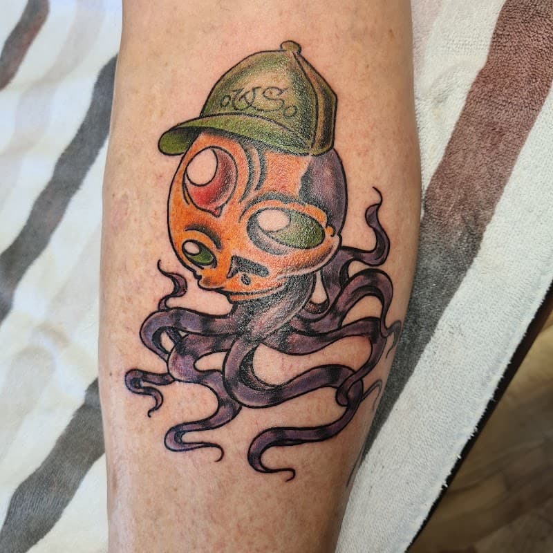 Kleurrijke octopus met een pet op het onderbeen.