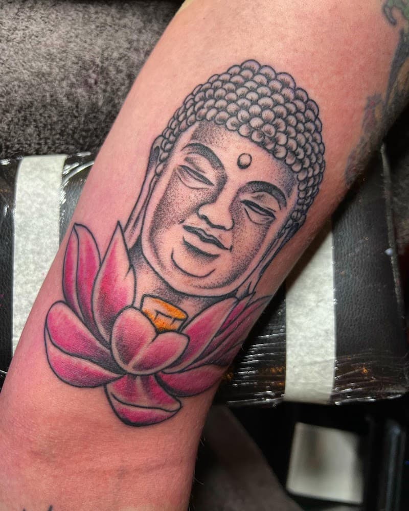 Boeddha hoofd met roze lotusbloem op onderarm.