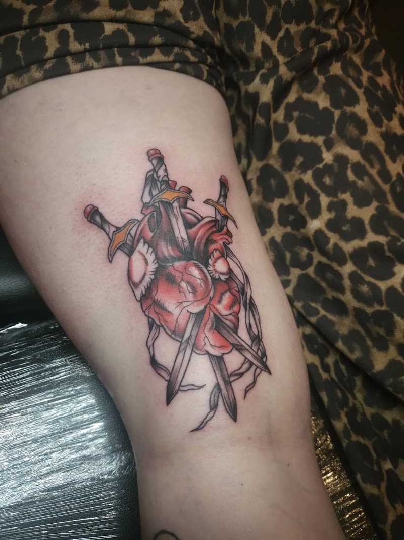 Neo-traditional tattoo van een anatomisch hart doorboord door drie zwaarden.