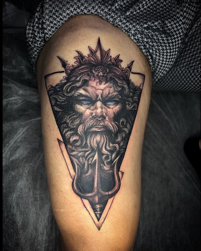 Realistische Poseidon tattoo met drietand en blauwe ogen in driehoek.