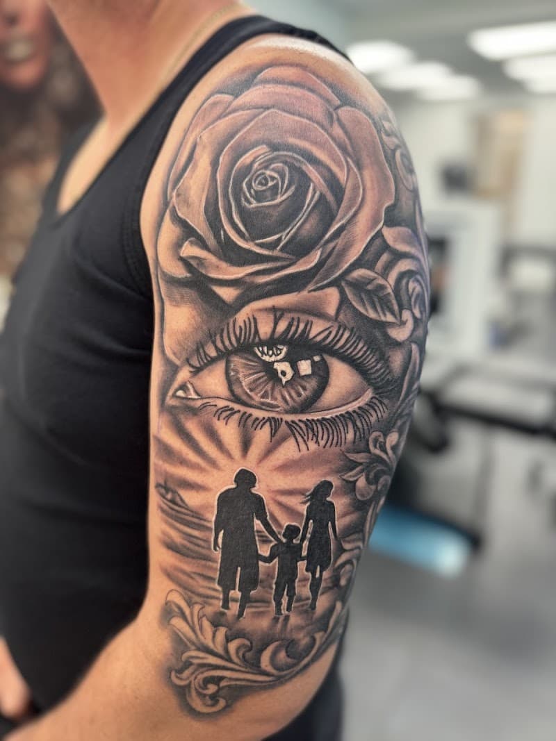 Realistische half-sleeve met roos, oog en familie silhouet op het strand.