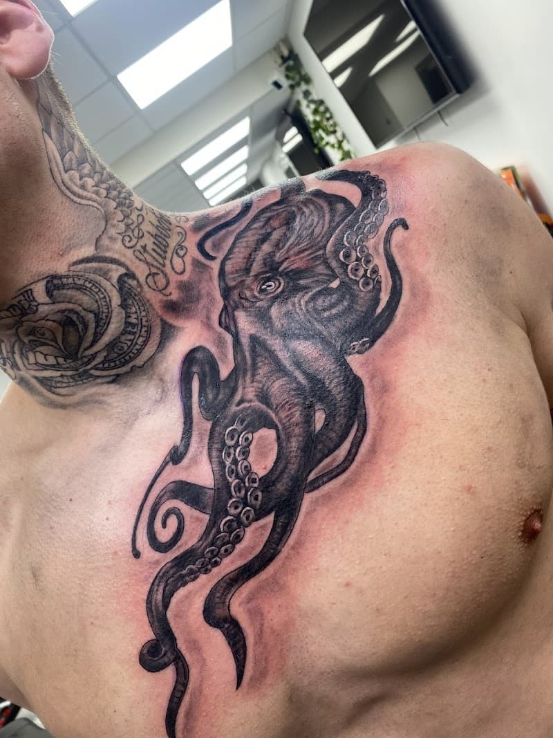 Realistische octopus tattoo in zwart-wit op de borst.