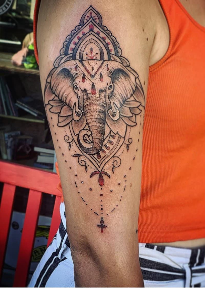 Olifant met mandala en rode accenten op bovenarm.