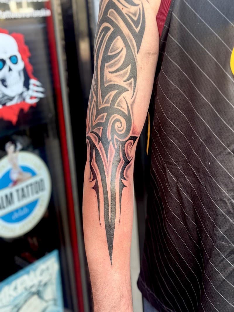 Grote tribal tattoo op de bovenarm in zwart-wit.