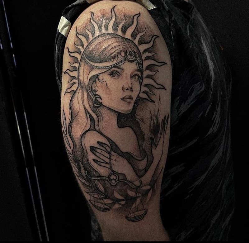 Blackwork tattoo van een vrouw met een zonnekroon en een weegschaal.