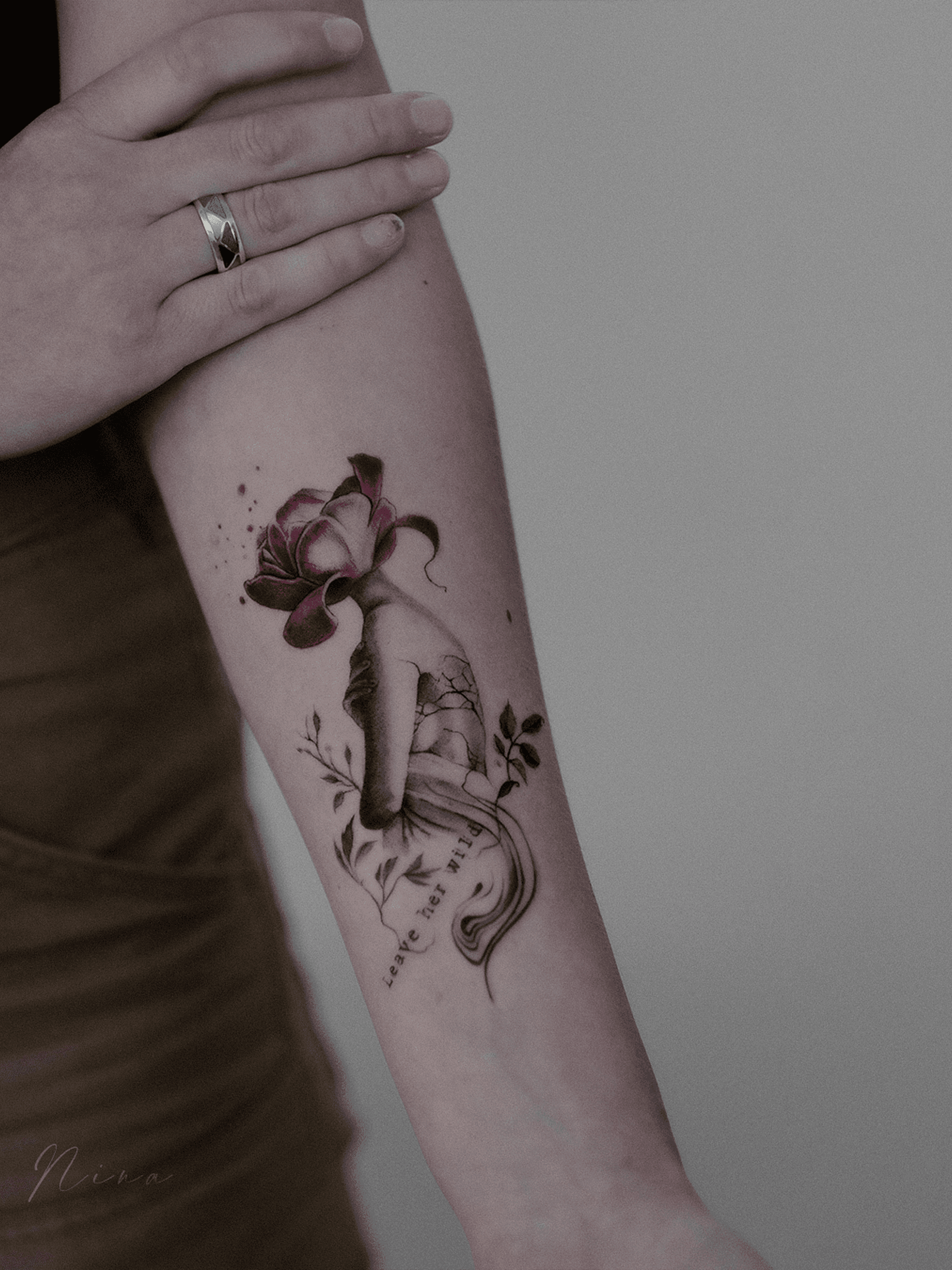 Illustratieve tattoo van een hand die een bloem wordt, met tekst 'Leave her wild'.