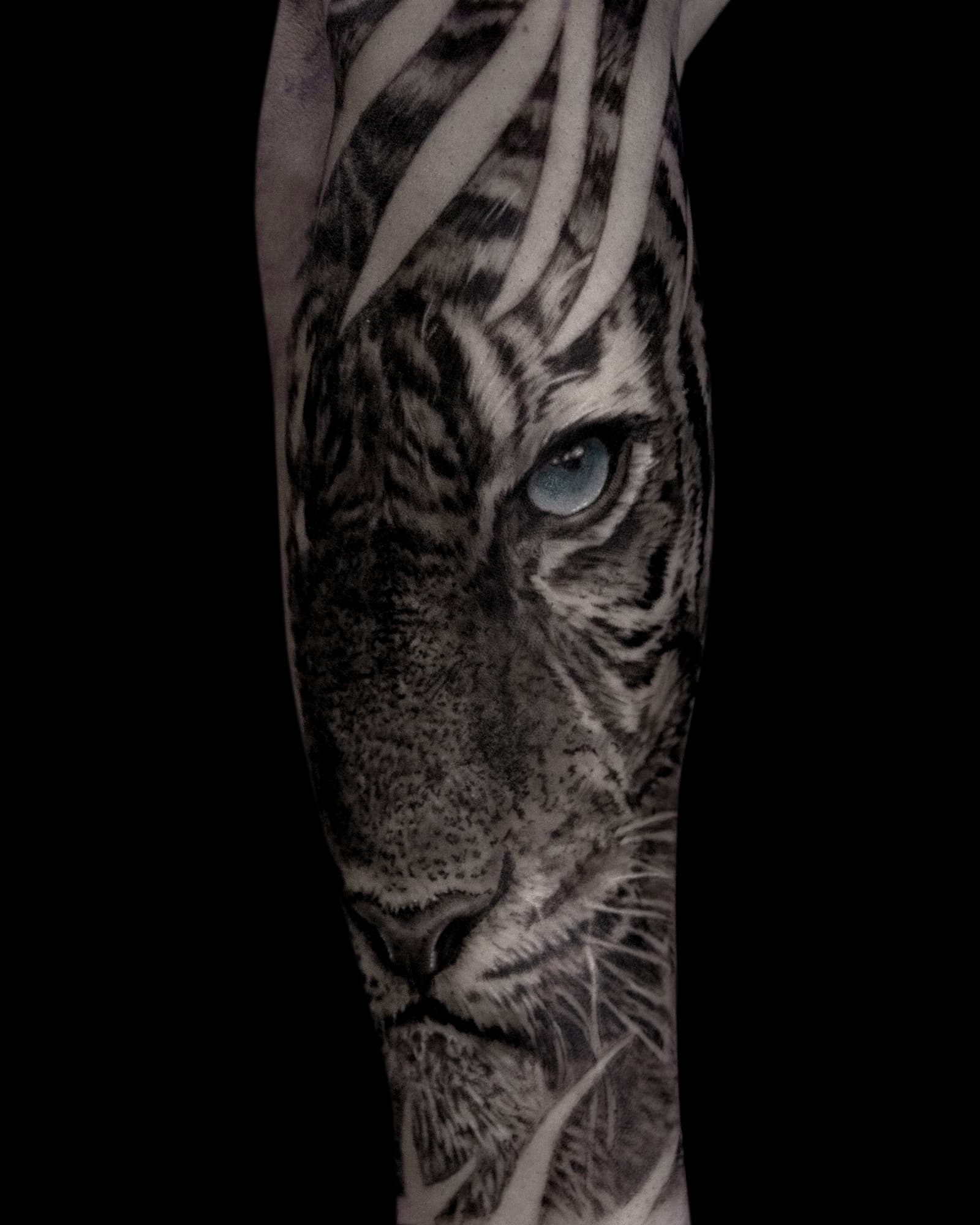 Realistische tijger met blauw oog op onderarm.