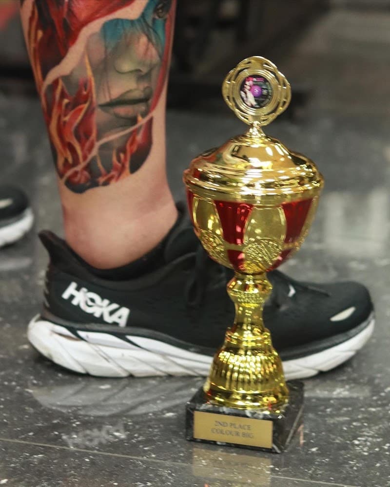 Kleurrijk portret van een vrouw met vlammen op het onderbeen.