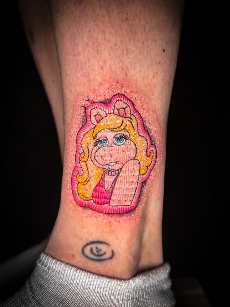 Kleurrijke Miss Piggy patch tattoo op enkel.