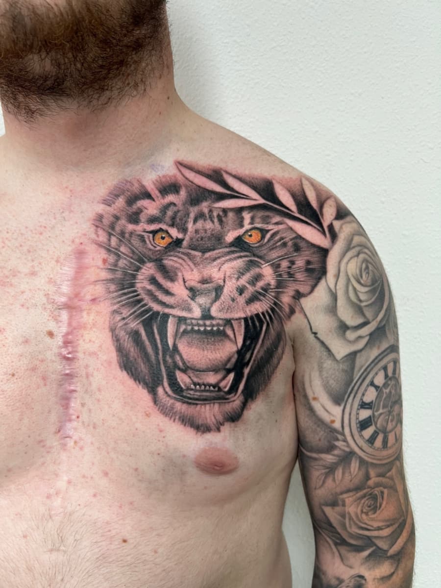 Realistische brullende tijger op borst, met rozen en klok op bovenarm.