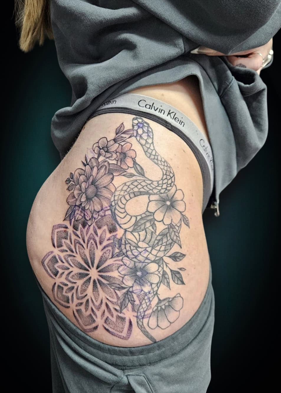 Slang met bloemen en mandala op heup/bovenbeen.