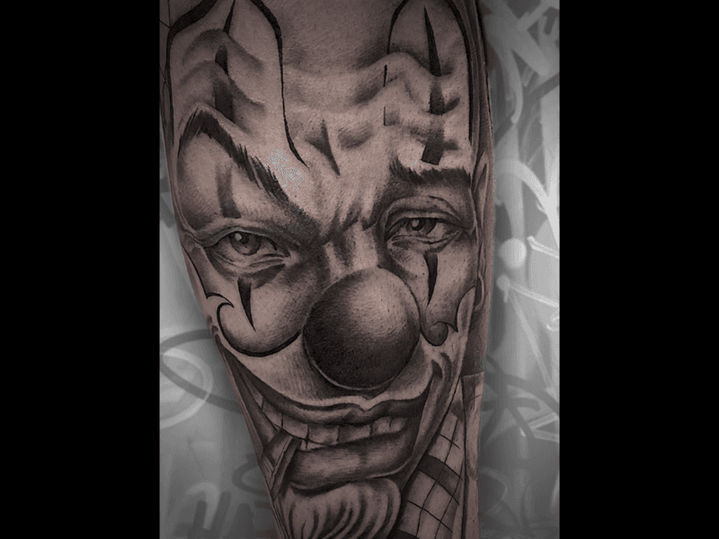 Close-up van een gedetailleerde zwart-wit clown tattoo.