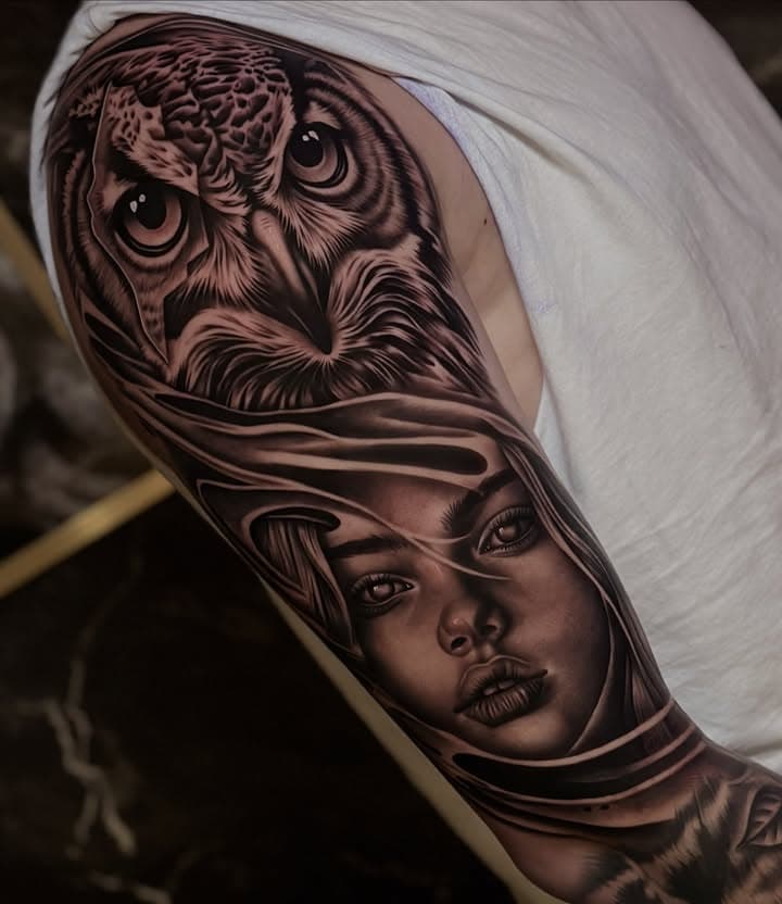 Realistische uil en vrouwenportret op bovenarm.