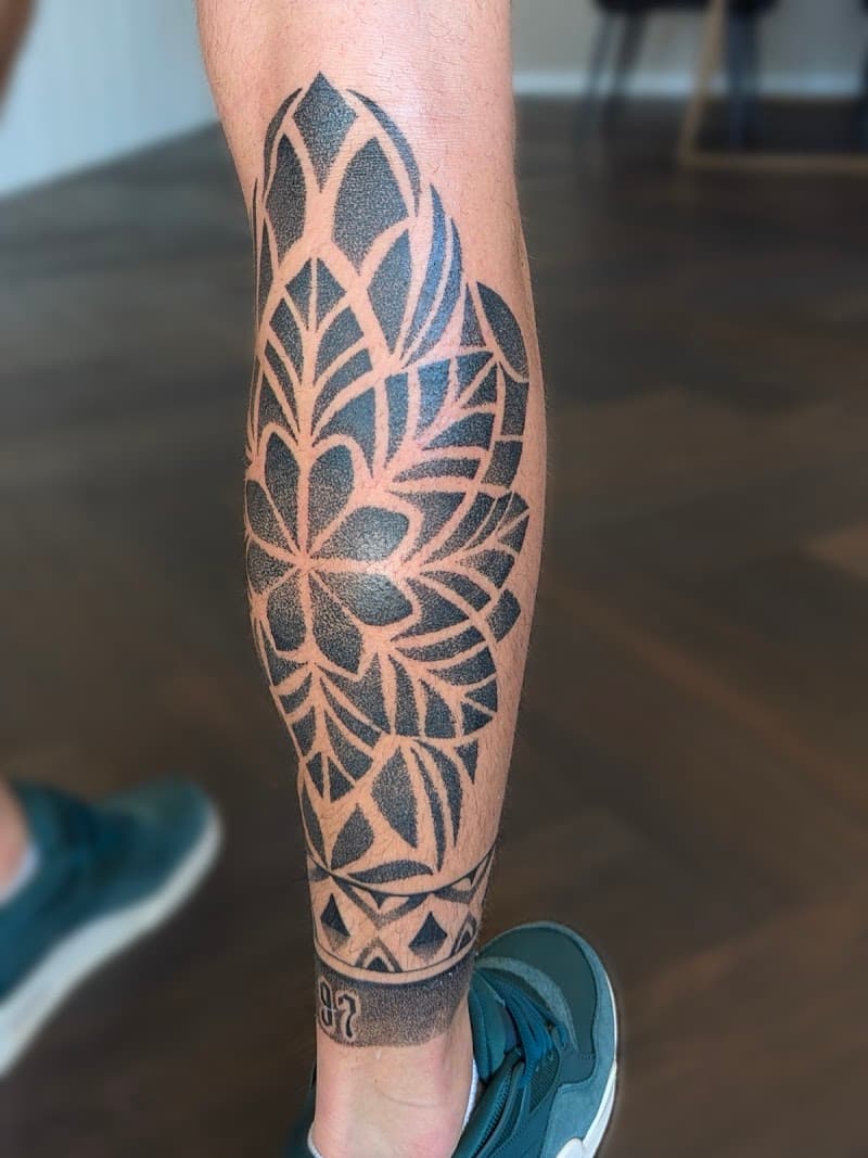 Grote geometrische mandala tattoo op onderbeen met dotwork shading.
