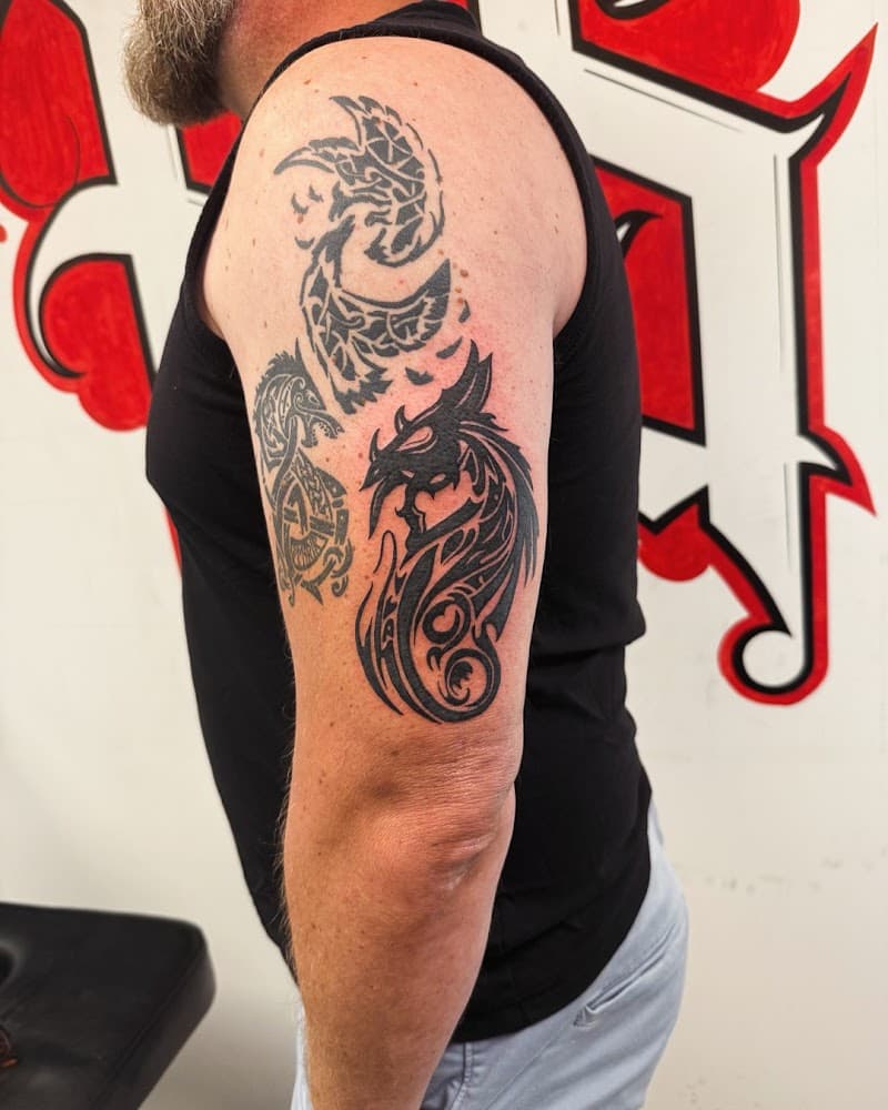 Drie zwarte tribale draken op de bovenarm.