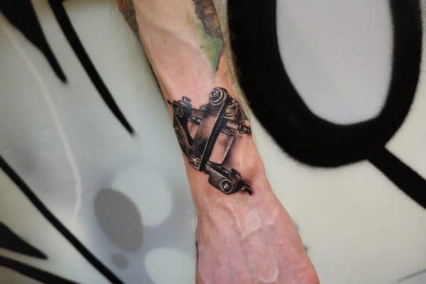 Realistische tattoo machine op de pols.
