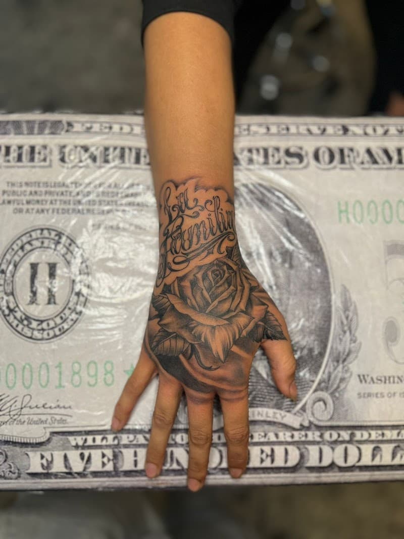 Zwart-grijze roos en 'La Familia' tekst op hand.