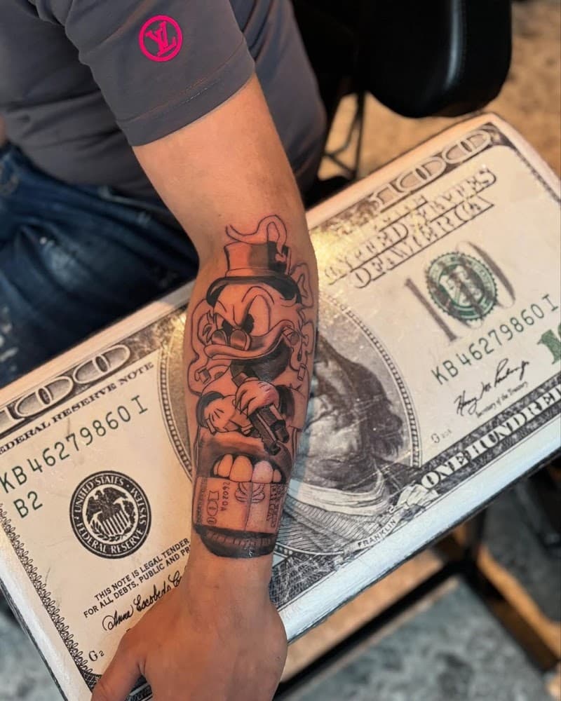 Dagobert Duck met pistool en geld in mond op onderarm.